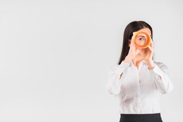 Foto mujer de negocios que mira a través del rollo de papel