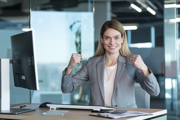 Mujer de negocios que puedo hacer todo retrato de una exitosa mujer de negocios que mira la cámara y sonríe trabajando en una oficina moderna con un gesto informático de éxito y victoria