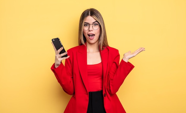 mujer de negocios que se siente feliz y asombrada por algo increíble. concepto de teléfono inteligente