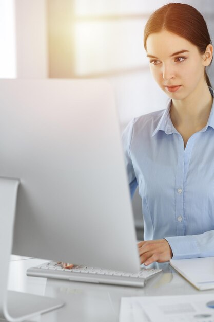 Mujer de negocios que trabaja con la computadora en el escritorio de vidrio en la oficina moderna Chica estudiante preparando la presentación o contable haciendo el balance Concepto de impuestos y auditoría