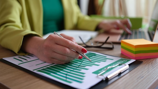 Mujer de negocios que trabaja con documentos en la mesa en el primer plano de la oficina