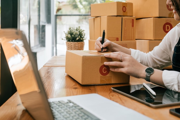 Mujer de negocios que trabaja en línea en el escritorio de la computadora portátil Trabajador de negocios exitoso freelance SME marketing en línea en el concepto de espacio de coworking en casa