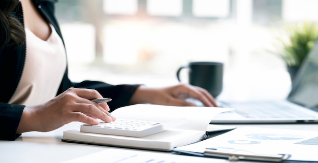 Mujer de negocios que trabaja en la oficina con documentos en su escritorio haciendo planificación analizando el informe financiero