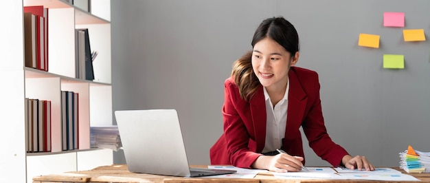 Mujer de negocios que usa una calculadora para hacer finanzas matemáticas en un escritorio de madera en la oficina y el trabajo empresarial estadísticas de contabilidad fiscal y concepto de investigación analíticax9