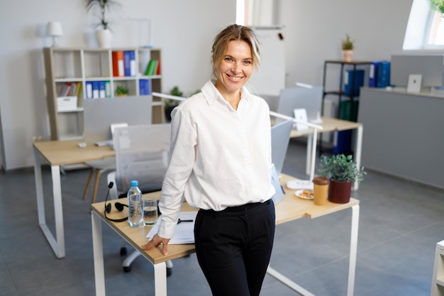 mujer de negocios, reclinado, contra, ella, escritorio, en, oficina