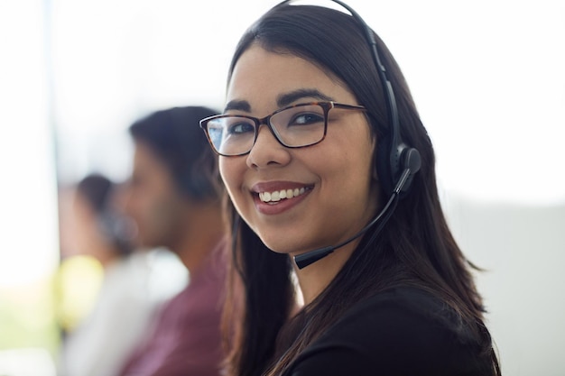 Mujer de negocios retrato de centro de llamadas y feliz por el servicio al cliente ventas de comercio electrónico y telemarketing rostro de consultora profesional o agente en el espacio de trabajo de telecomunicaciones para contactarnos o chat virtual