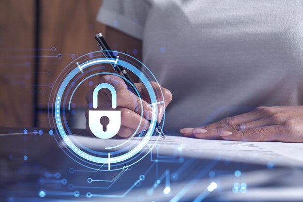 Una mujer de negocios con ropa informal firma el contrato para evitar la probabilidad de riesgos en la seguridad cibernética Iconos de holograma de candado sobre el escritorio de trabajo