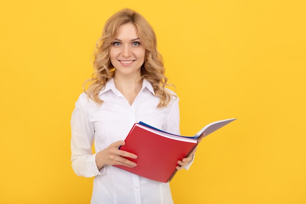 Mujer de negocios rubia feliz en camisa blanca haciendo notas en el Bloc de notas o cuaderno, ejecutivo.