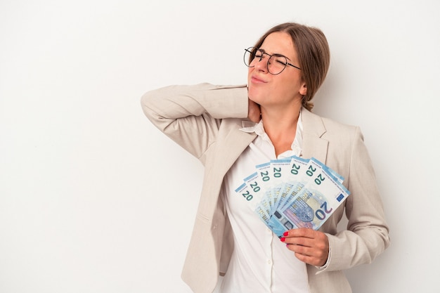 Mujer de negocios rusa joven sosteniendo billetes aislados sobre fondo blanco tocando la parte posterior de la cabeza, pensando y haciendo una elección.