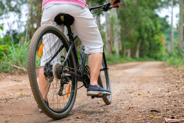 Mujer de negocios senior paseo femenino o bicicleta de montaña para hacer ejercicio saludable en el fin de semana de verano