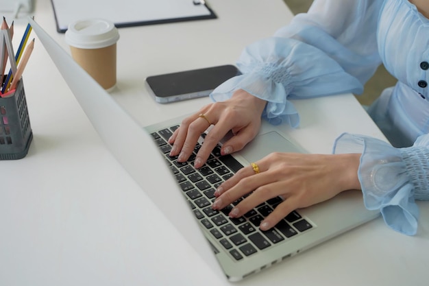 Mujer de negocios sentada en la oficina analizando las tendencias del mercado de ganancias con informes de tabletas y papel colocados sobre la mesa Concepto de negocio asiático