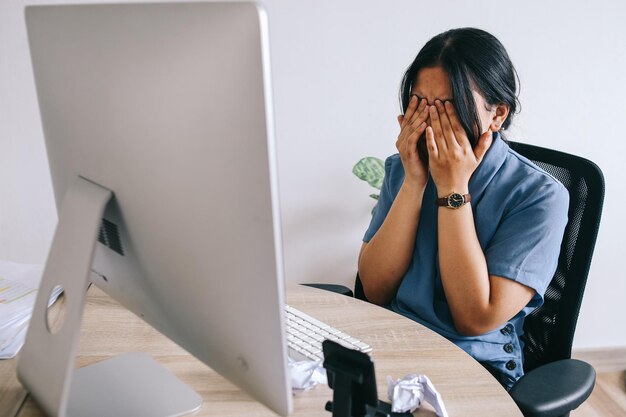 Mujer de negocios sentada en una silla de oficina buscando estresada pensando en cómo resolver el problema