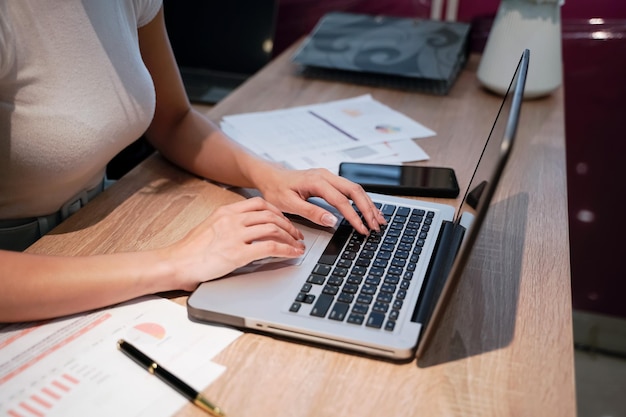 mujer de negocios, sentado, en, un, escritorio, mujer de negocios, manos, descansar, en, computadora de computadora portátil, teclado