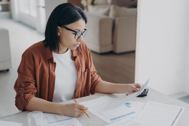 Una mujer de negocios seria está examinando documentos Estrategia profesional y comercial inteligente