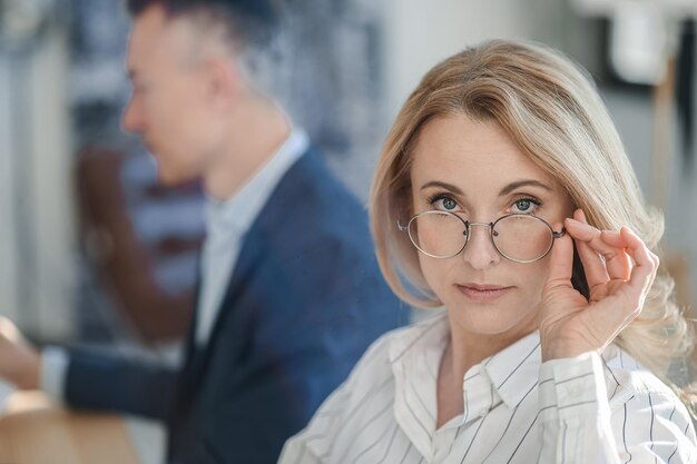 Mujer de negocios seria rubia que trabaja en la oficina