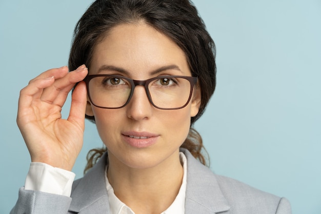 Mujer de negocios seria segura de sí misma toca anteojos