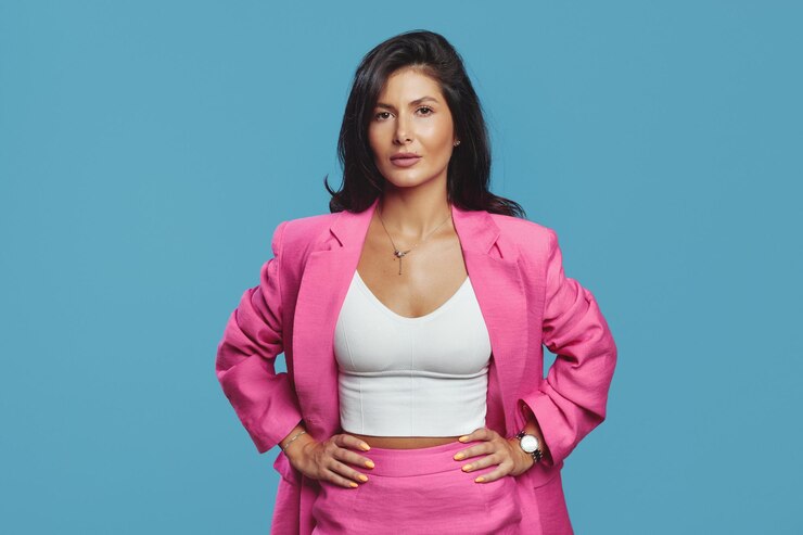 Mujer de negocios seria vestida con un elegante traje rosa tomados de la mano en la cintura