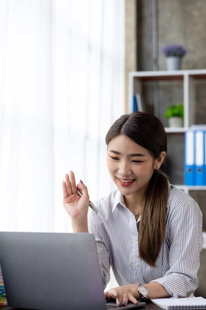 Mujer de negocios con un socio comercial a través de una videollamada en una computadora portátil que se está reuniendo con un socio para planificar las operaciones y las finanzas de una empresa emergente conjunta Concepto de administración empresarial