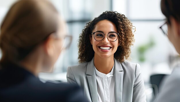 Mujer de negocios sonriente con anteojos hablando con un colega en la oficina