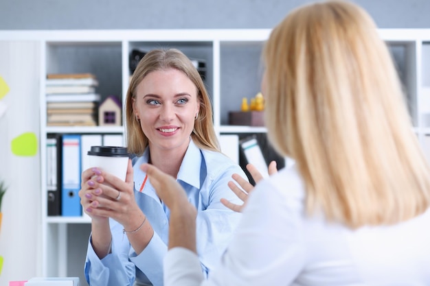 Una mujer de negocios sonriente bebiendo café.