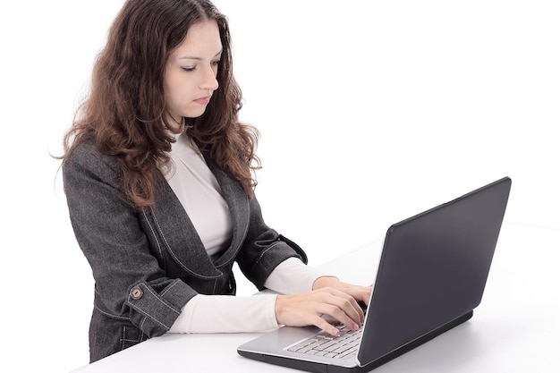 Mujer de negocios sonriente escribiendo en la computadora portátil y mirando hacia atrás