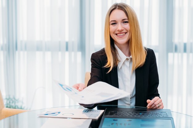 Mujer de negocios sonriente feliz en el espacio de trabajo de la oficina