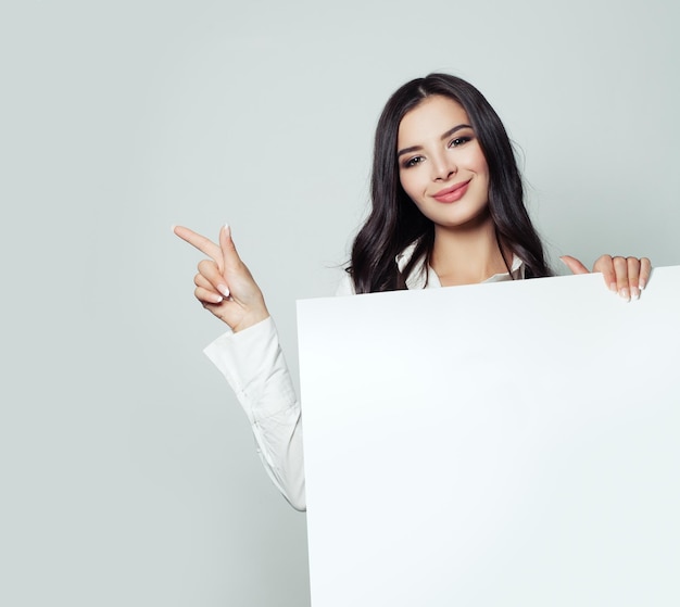 Mujer de negocios sonriente con fondo blanco de tablero vacío con espacio de copia para marketing publicitario o colocación de productos Retrato de mujer de negocios exitosa