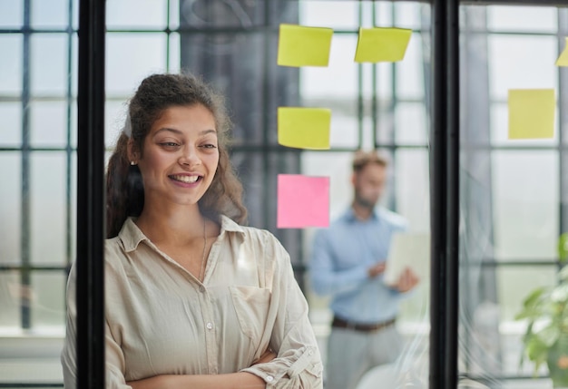 Mujer de negocios sonriente mirando por la ventana