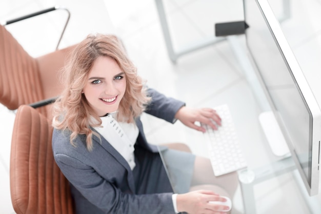 Mujer de negocios sonriente sentada detrás de un escritorio