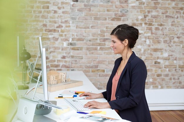 Mujer de negocios sonriente trabajando en un escritorio en la oficina