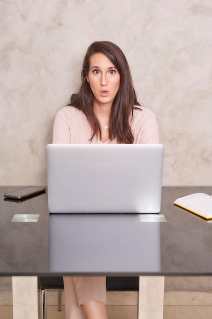 Mujer de negocios sorprendida con su computadora portátil