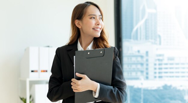 Mujer de negocios sosteniendo archivos dentro de la oficina moderna