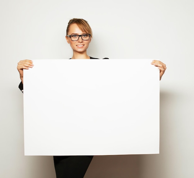 Mujer de negocios sosteniendo una cartelera en blanco