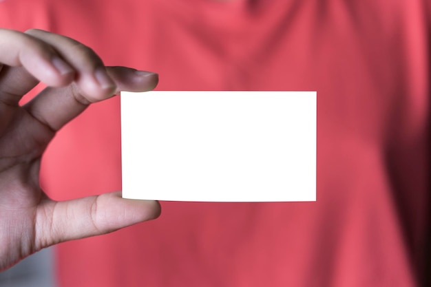 Mujer de negocios sosteniendo y mostrando el primer plano de la tarjeta de plástico en blanco en la mano femenina