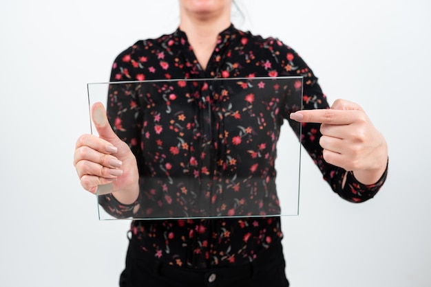 Mujer de negocios sosteniendo y señalando vidrio transparente mientras presenta información importante Mujer con camiseta floral que muestra pancarta rectangular para promoción de marca