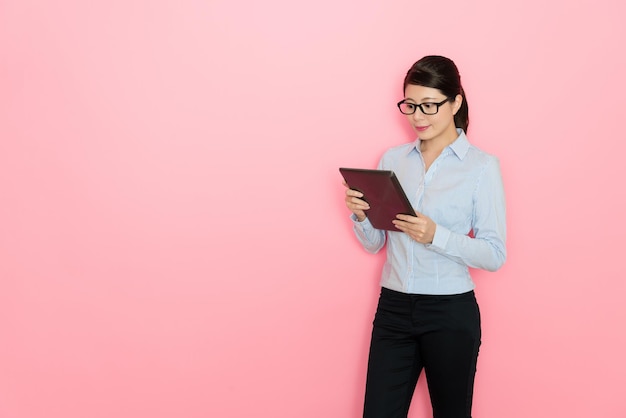 mujer de negocios sosteniendo una tableta digital y revisando la información en línea