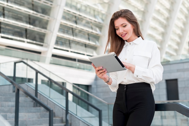 Mujer de negocios con una tablet en la calle