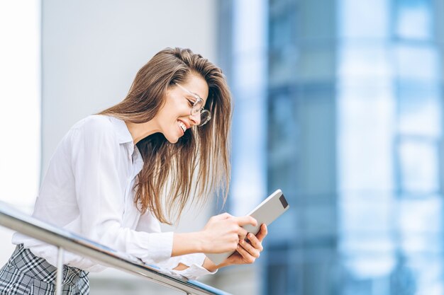 Mujer de negocios con tableta cerca del moderno centro de negocios.