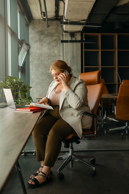 Mujer de negocios de talla grande que trabaja en una oficina profesional