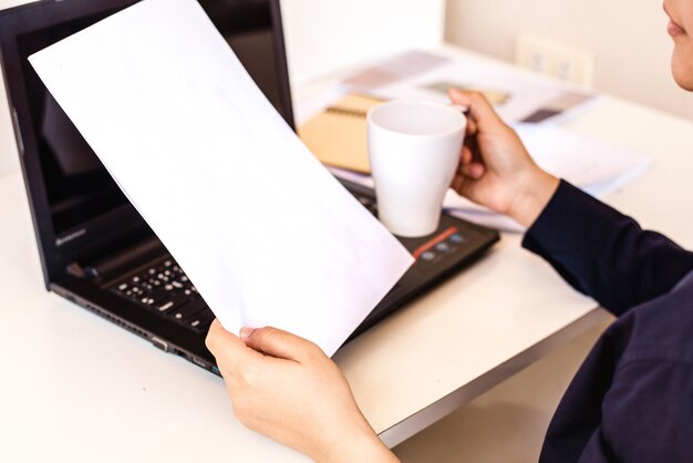 Mujer de negocios con una taza de café y archivos