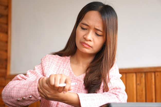 La mujer de negocios tiene debilidad muscular en las manos