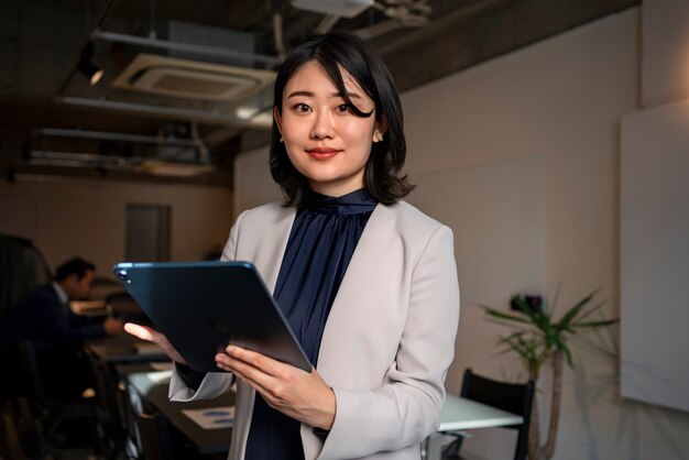 Foto mujer de negocios de tiro medio trabajando en ipad