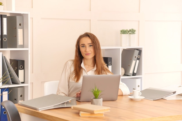 Mujer de negocios trabaja en una computadora portátil. retrato de una mujer en la oficina.