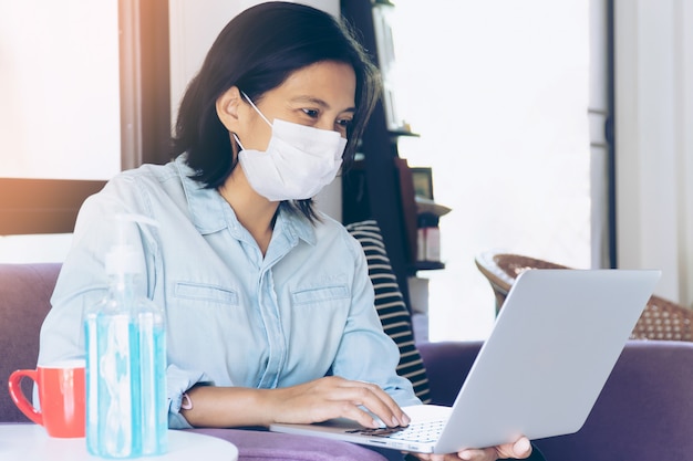 Mujer de negocios trabajando desde casa mientras ella tiene que quedarse en casa para auto cuarentena. Virus Corona o Concepto COVID-19.