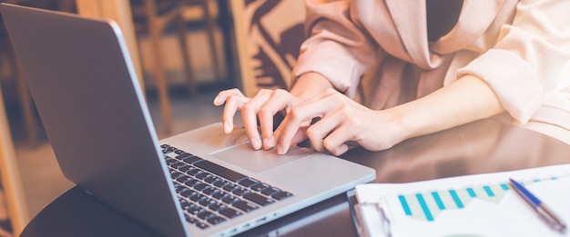 Foto mujer de negocios trabajando con una computadora portátil en la oficina. para banner web.