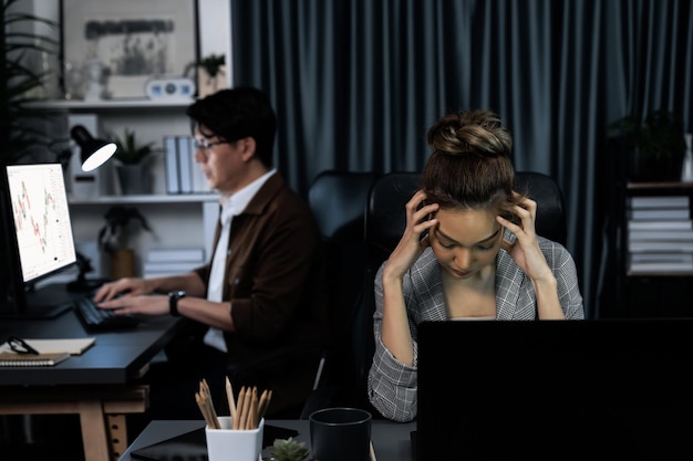 Mujer de negocios trabajando con estiramiento mientras su compañero de trabajo invierte acciones Infobahn