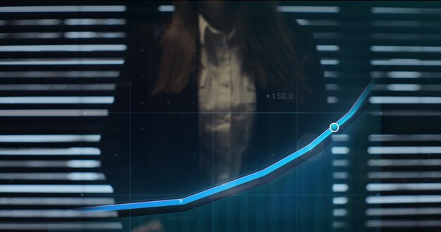 Mujer de negocios trabajando en un gráfico financiero holográfico usando realidad aumentada para verificar la economía