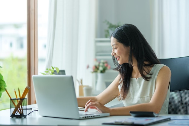 Una mujer de negocios trabajando en un nuevo proyecto con una computadora portátil en una oficina moderna