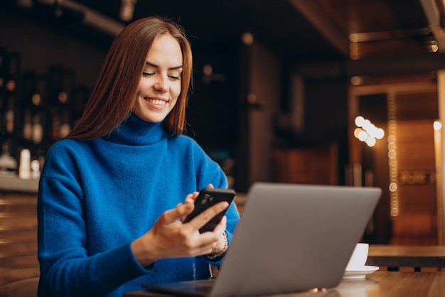 Mujer de negocios trabajando en un portátil en un café