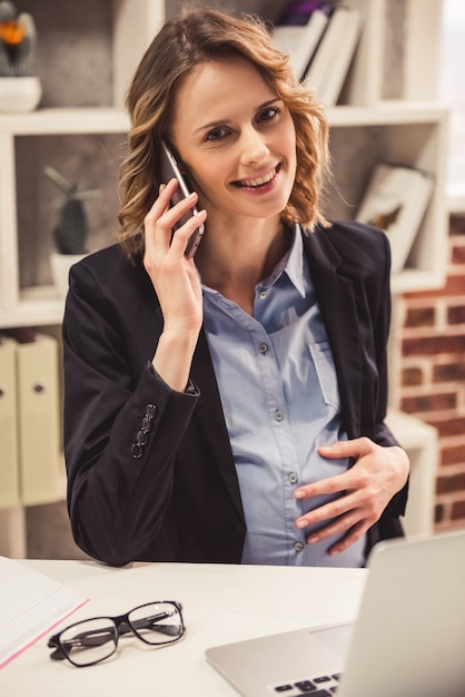 Mujer de negocios en traje está hablando por el teléfono móvil.